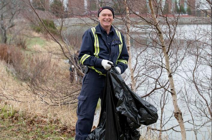 Facilities Management employee Dave Sutton at the campus cleanup, cleaning up Burton's Pond area.